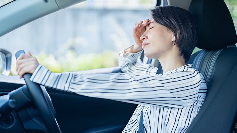 車の中で疲れている女性