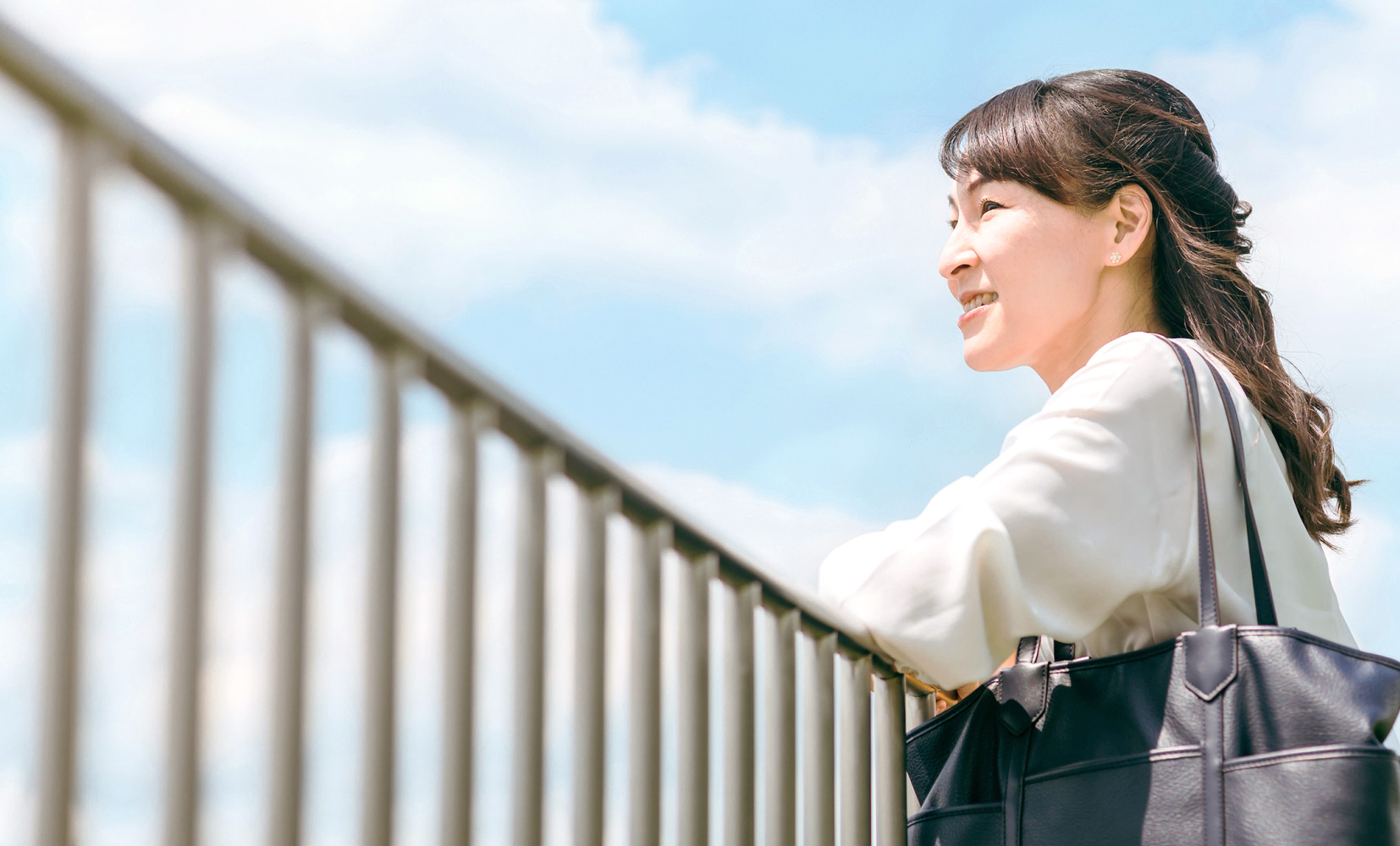 青空を眺めて気分転換する女性