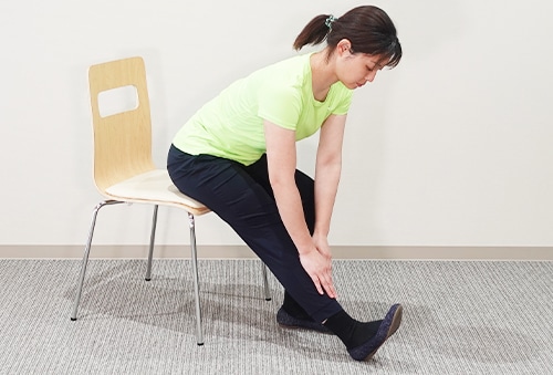 太もも後ろのストレッチを行う女性