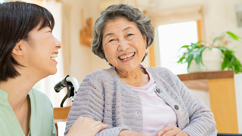 笑顔で会話するシニア女性とスタッフ