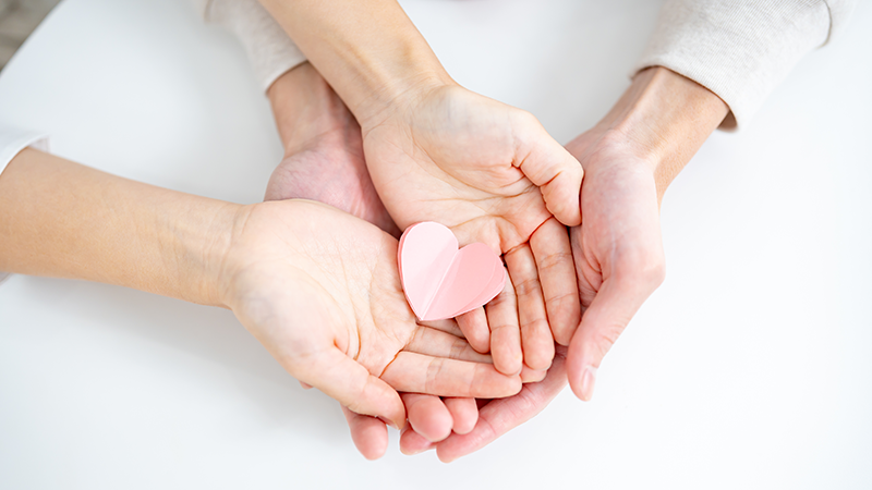 ハートの折り紙を持つ手