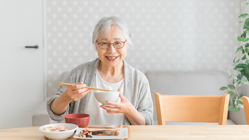 姿勢良く食事する高齢女性