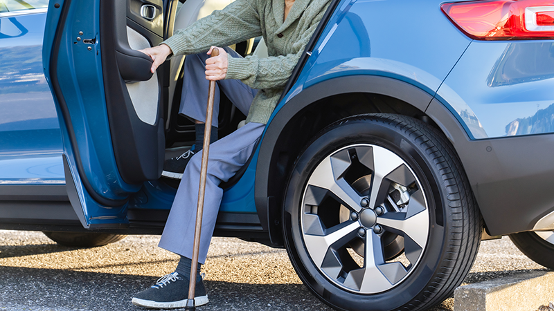 車から降りるシニア男性