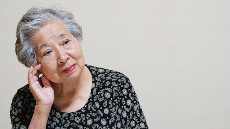 相手の声が聞こえにくく困惑する高齢者女性