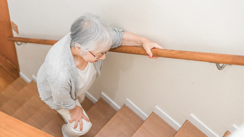 階段を上る高齢女性