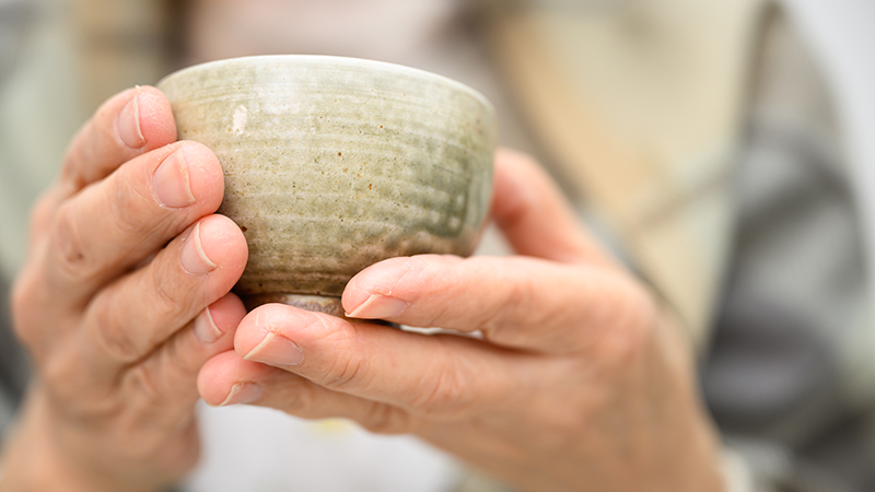 温かいお茶を楽しむ高齢者