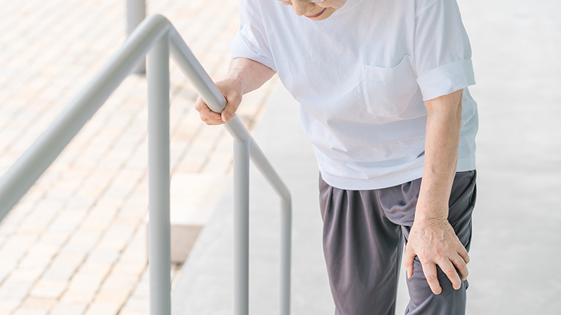 階段で息切れするシニア女性