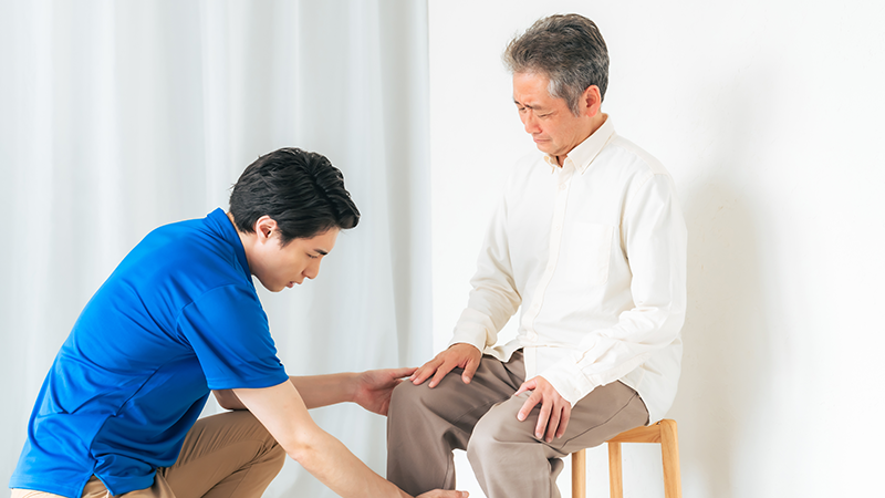 膝を診てもらうシニア男性