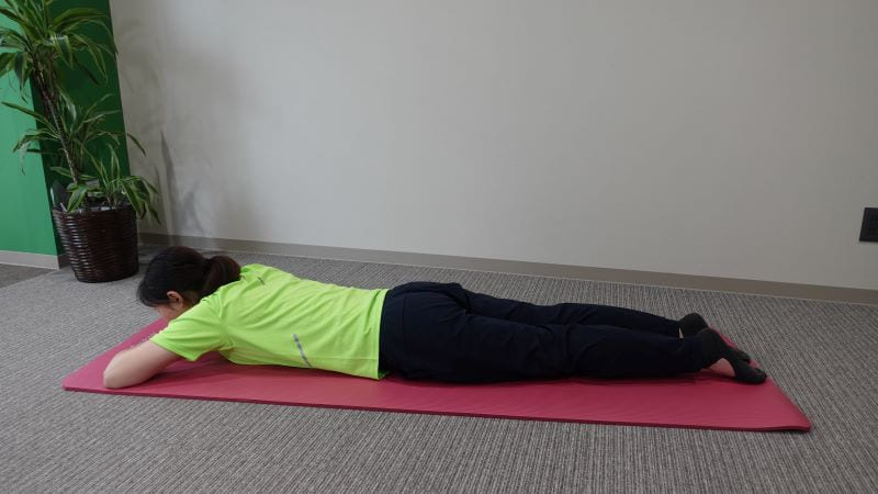 うつ伏せでお尻を鍛える運動を行う女性