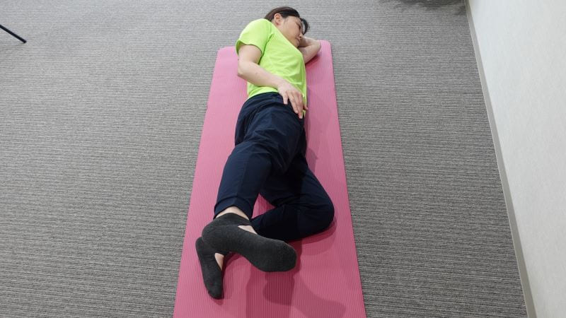 横向きでお尻を鍛える運動を行う女性