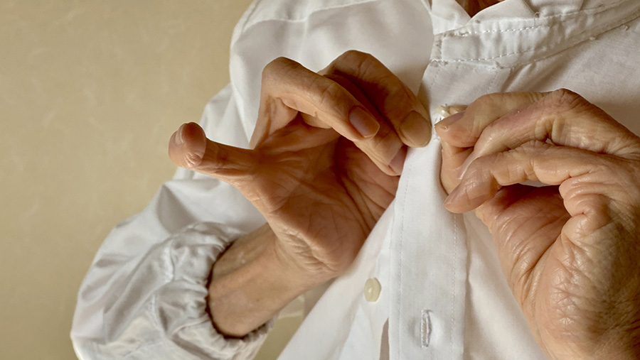 ボタンをとめるシニア女性