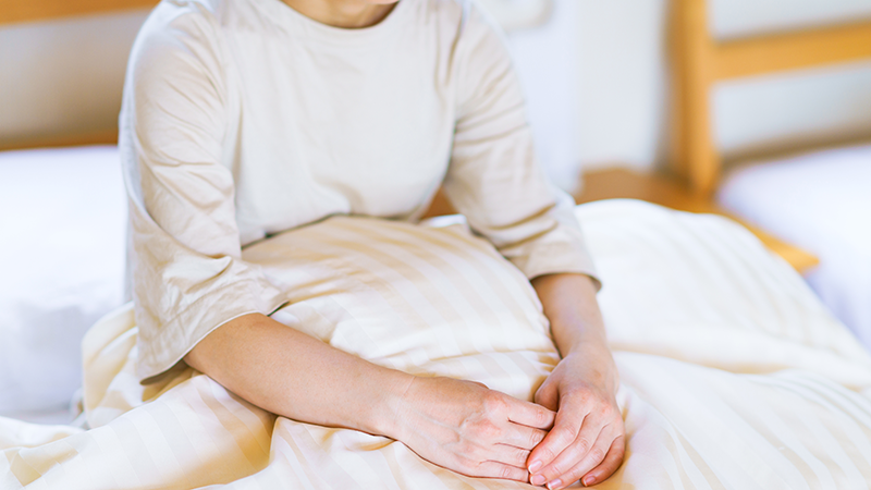 ベッドの上で座っている女性