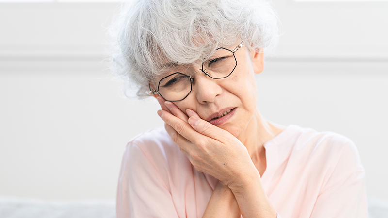 口を抑えるシニア