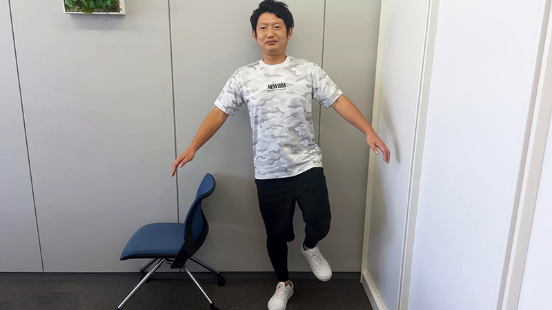 片足立ちをする男性