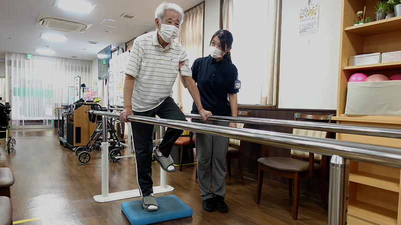 平行棒で運動をするシニア男性