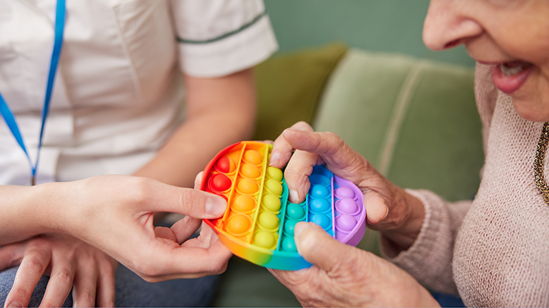 作業療法士から指先の訓練を受ける高齢者