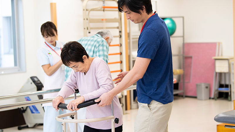 高齢者の歩行トレーニングを施す理学療法士
