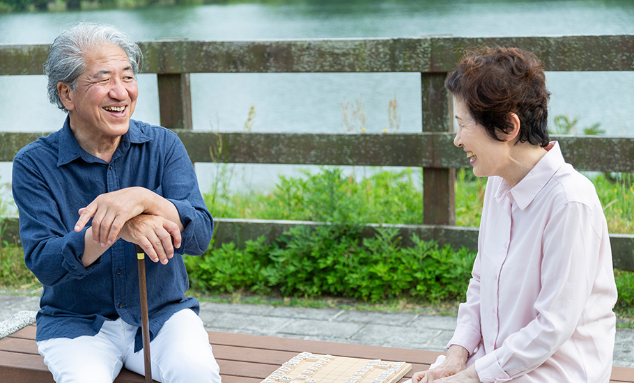 ウォーキングの途中で笑いながら休憩する夫婦