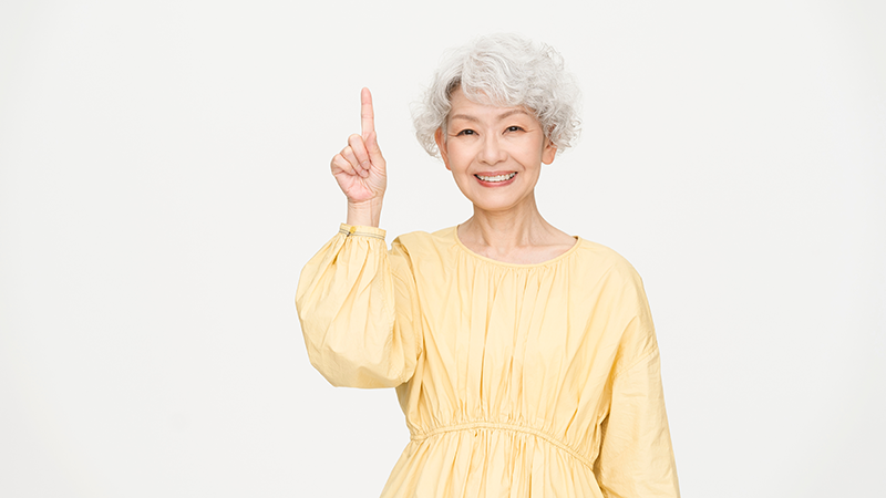人差し指を上げている高齢者