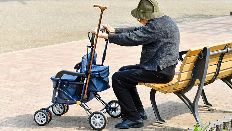 公園のベンチで休憩するシニア
